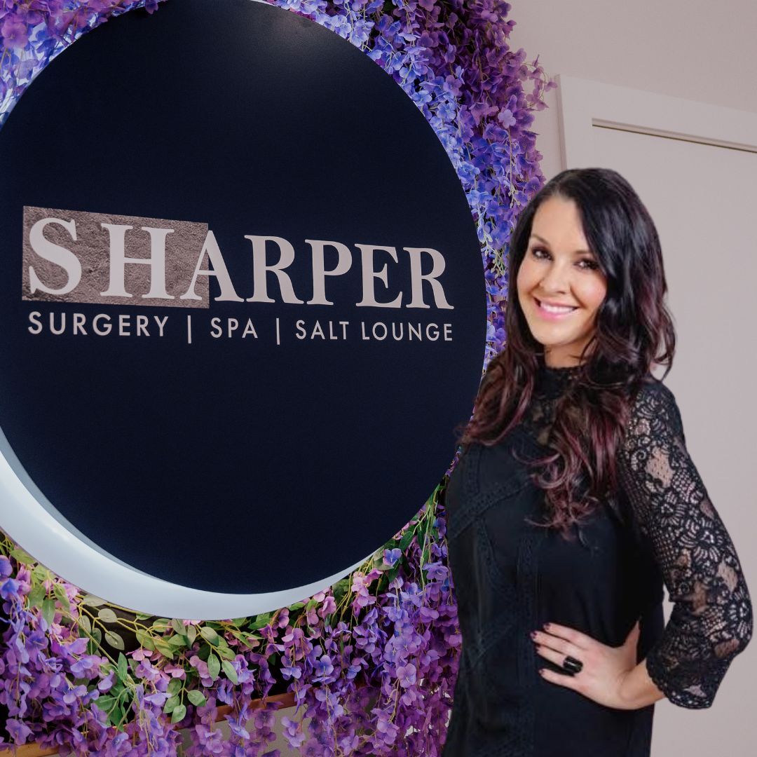 Woman smiling beside Harper Spa sign.